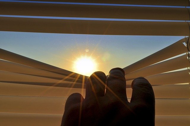Wschód słońca przez rolety materiałowe od firmy Okno-Świat